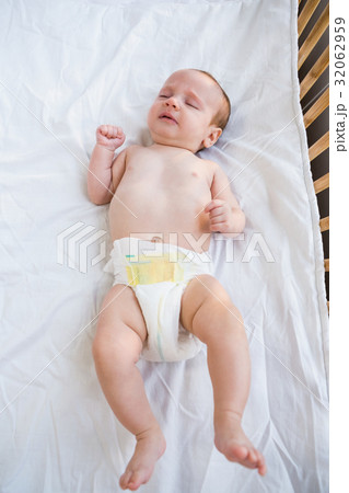 Baby lying on baby bed Baby lying on baby bed 32062959