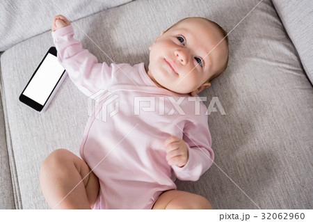 Baby lying on sofa in living room Baby lying on sofa in living room 32062960