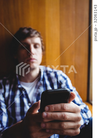 Student using mobile phone near window 32063143