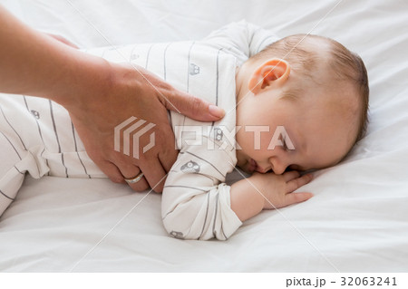 Mom putting baby to sleep in baby bed Mom putting baby to sleep in baby bed 32063241