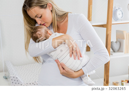 Mother holding and kissing her baby boy 32063265