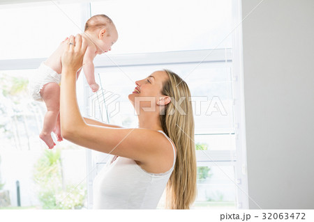 Mother playing with her baby in living room Mother playing with her baby in living room 32063472