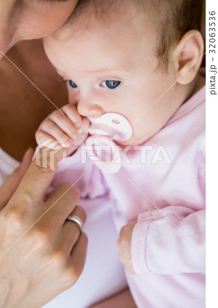 Mother playing with her baby in bedroom 32063536