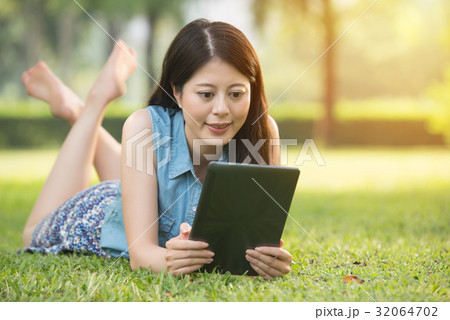 beauty asian woman using digital tablet on grass 32064702