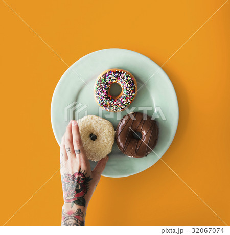 Hand with tattoo reaching for donut 32067074