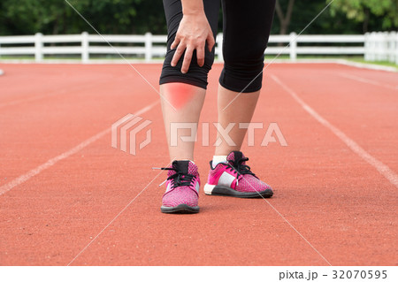 Middle aged woman runner knee pain during training 32070595
