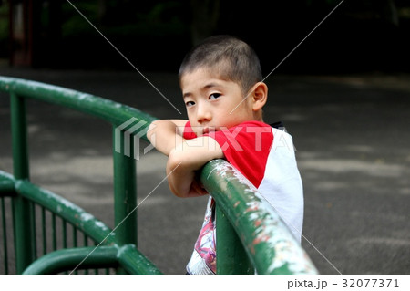 柵に寄り掛かって退屈そうな男の子 柵に寄り掛かって退屈そうな男の子 32077371