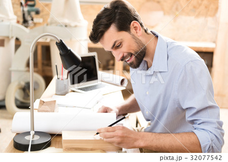 Cheerful bearded lumber master working with wooden Cheerful bearded lumber master working with wooden 32077542
