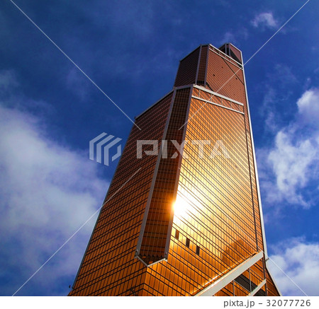 The skyscraper reflects the sunbeam. 32077726
