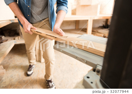 Energetic woodworker is standing in his workshop Energetic woodworker is standing in his workshop 32077944