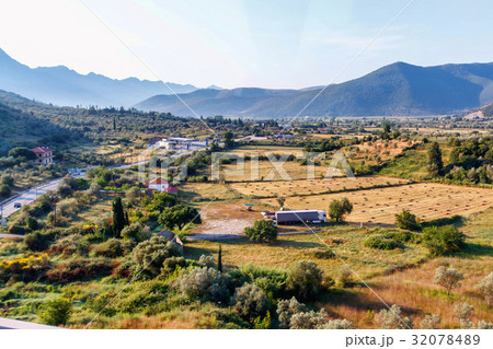 View on fields, houses and mountains at sunset View on fields, houses and mountains at sunset 32078489