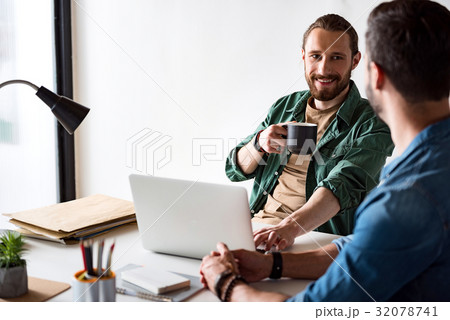 Merry smiling worker sitting in office 32078741