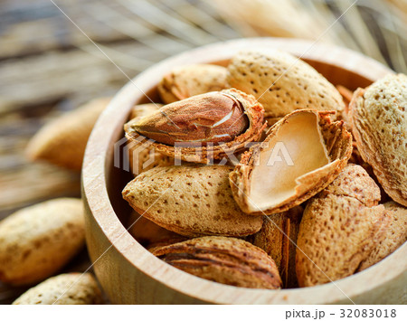Almonds in a bowl on wooden background 32083018