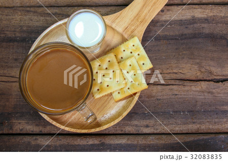 cup of coffee and a biscuit on wooden background  32083835