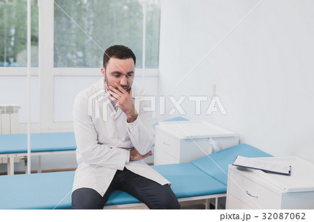 Thoughtful doctor sitting in a operating room with 32087062