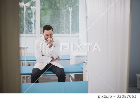 Tired doctor sitting alone in hospital ward. 32087063