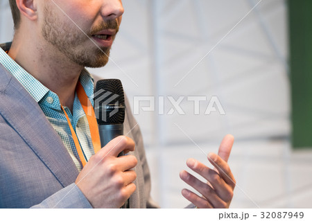 Speaker at conference holding microphone Speaker at conference holding microphone 32087949