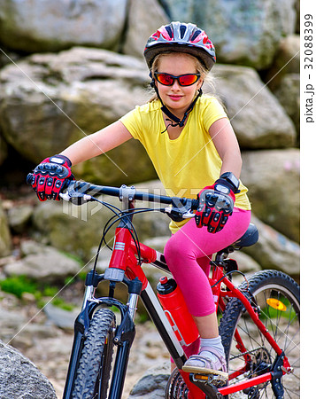 Child on bicycle ride mountain. Girl traveling in 32088399