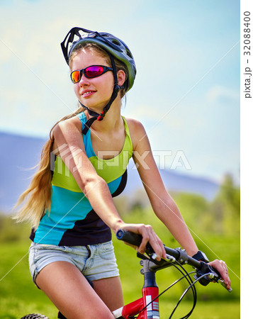 Woman traveling bicycle in summer park. 32088400