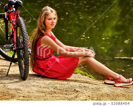 Bikes cycling girl into park. Girl sits leaning on Bikes cycling girl into park. Girl sits leaning on 32088404