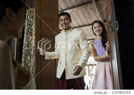 A man and woman are opening the door and looking at the bride. 32090204