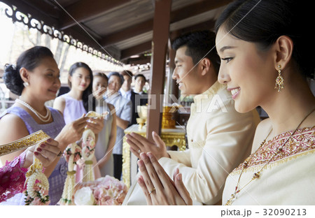 People are holding garlands while the couple are smiling. People are holding garlands while the couple are smiling. 32090213
