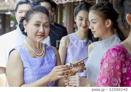 A woman is giving something to a girl 32090240