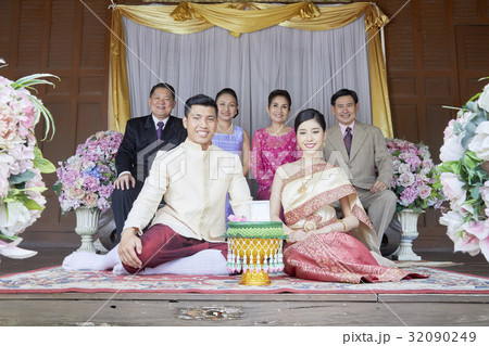 Groom and bride are taking photo with their parents. 32090249