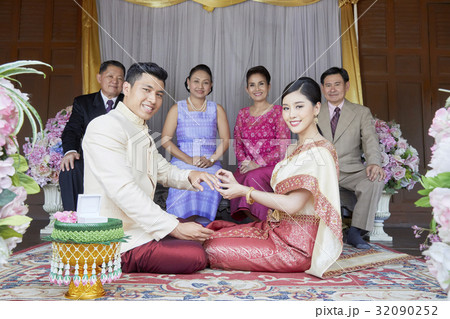 A picture of couple with their parents at their wedding ceremony. 32090252