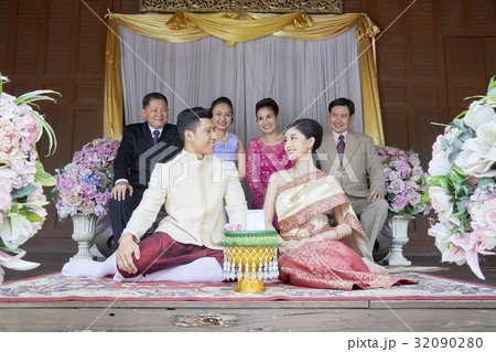 a couple with their parents are sitting and smiling together. a couple with their parents are sitting and smiling together. 32090280