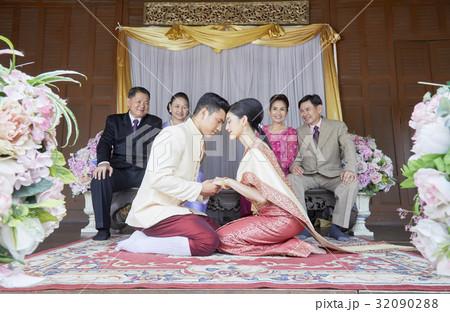 bride and groom are sitting and holding hand each other 32090288