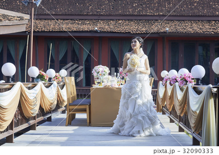 beautiful young bride with punch of flowers is looking away at the wedding setting  32090333