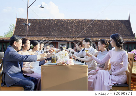 Everyone is toasting together for happiness of married couple in the front yard Everyone is toasting together for happiness of married couple in the front yard 32090371