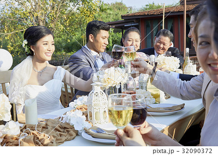 the bride is clinking wine while the others are chatting and toasting together the bride is clinking wine while the others are chatting and toasting together 32090372