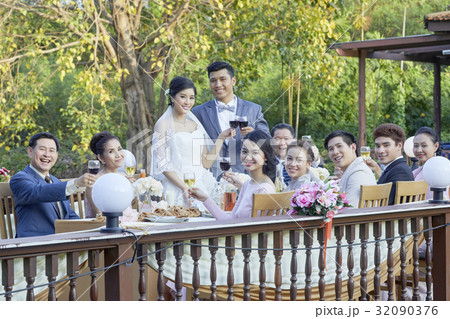 the married couple are standing and toasting happily with guests 32090376