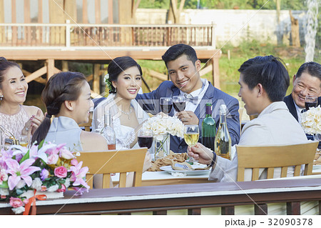The married couple are raising wine glass while the others are chatting and clinking 32090378