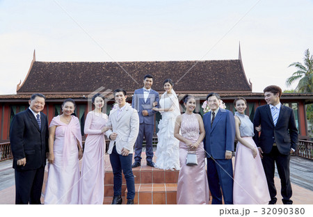 A photograph of married couple and their guests at their wedding with pair by pair 32090380