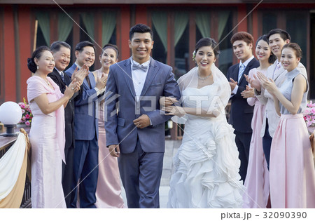 guests are clapping in background of a happy newlywed couple guests are clapping in background of a happy newlywed couple 32090390