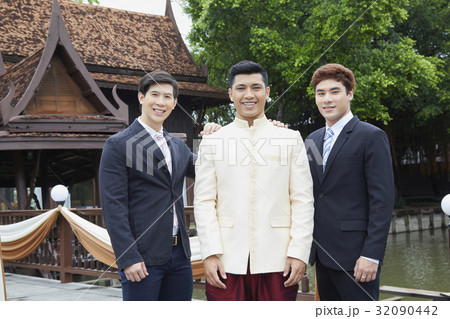 A groom and his friends are taking a photo in the garden. 32090442