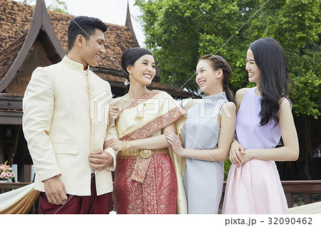 A couple is talking happily with two girls in the wedding. 32090462
