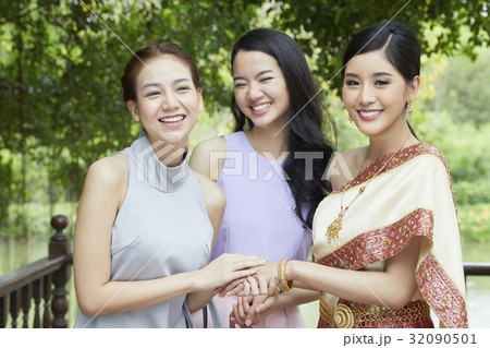 A photo of two girls and a bride holding hands and smiling together  A photo of two girls and a bride holding hands and smiling together  32090501