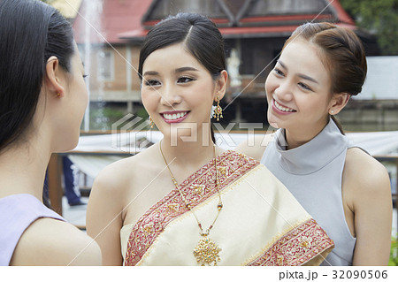 The bride and bridesmaid are looking and smiling with the other people The bride and bridesmaid are looking and smiling with the other people 32090506