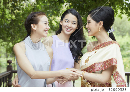 a photo of a bride and two girls taking hands and smiling together 32090523