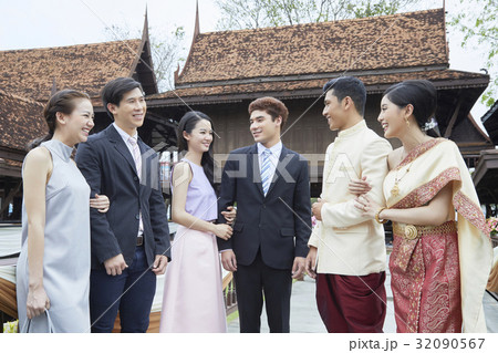 A married couple is standing and having fun together with friends. 32090567