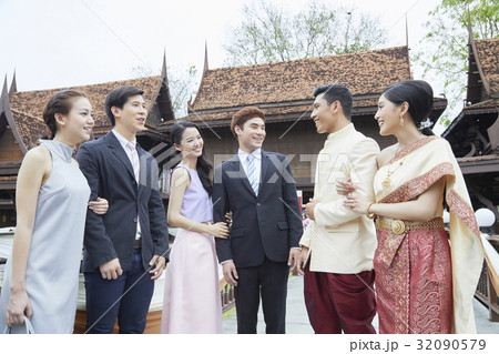 a photo of married couple and two couples greeting and smiling together. 32090579