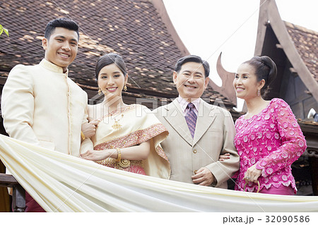 a photo of a groom and bride smliling next to their parents. 32090586