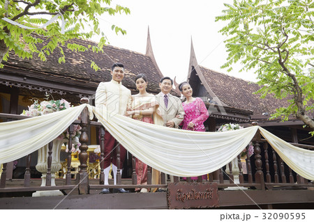 a photo of happy couple standing with their parents in a balcony. a photo of happy couple standing with their parents in a balcony. 32090595