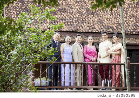 a photo of a groom and bride standing next to their parents on balcony. a photo of a groom and bride standing next to their parents on balcony. 32090599