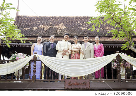 a photo of a bride and groom standing between their parents. 32090600