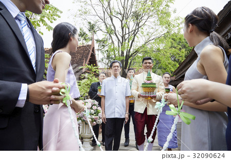 a groom is holding a wedding gift while other people are looking at him 32090624